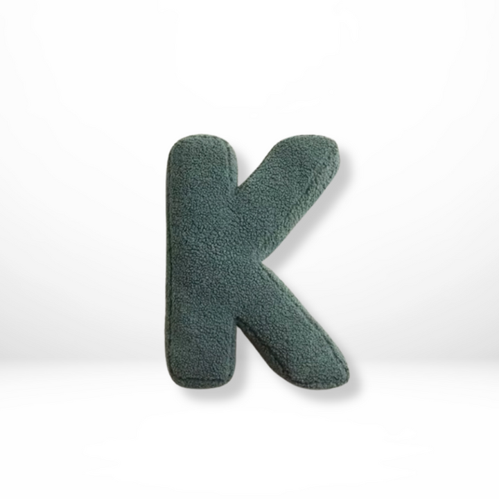 Luxurious velvet 'O' alphabet pillow, a soft decorative furnishing for elegant home interior design.
