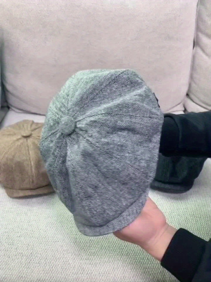 Side view of men's retro flat cap, herringbone pattern, classic vintage fashion.