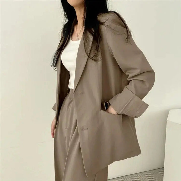 Side profile of model wearing women's elegant tailored suit, sophisticated look.