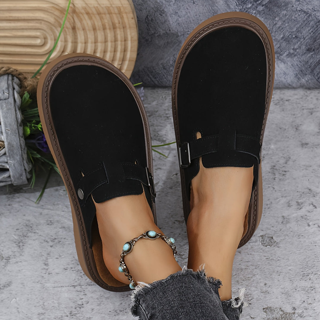 Contemporary women's platform clogs with an adjustable strap & closed toe.