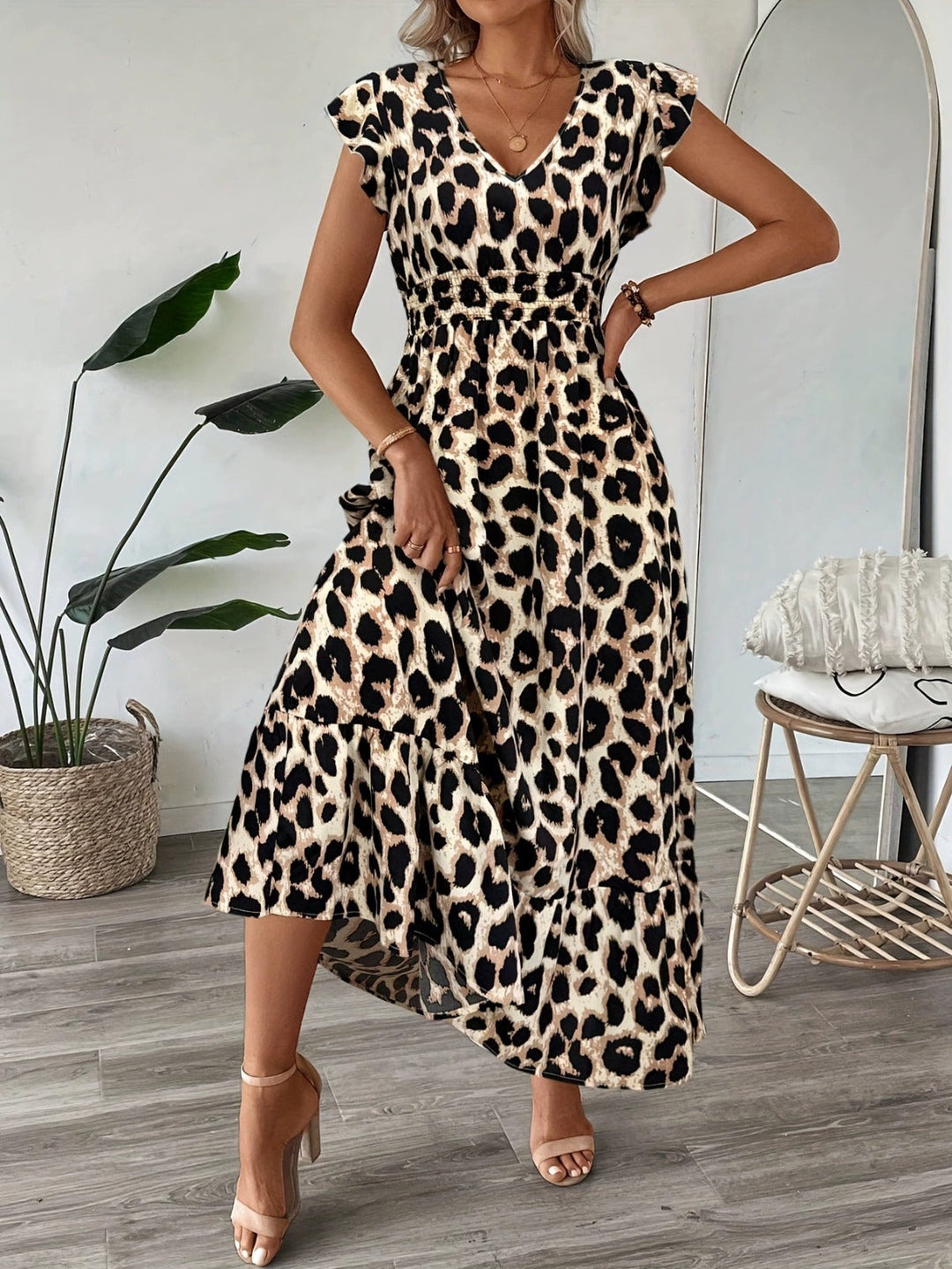 Elegant embroidered summer midi dress, V-neck, flared, styled for a special occasion.