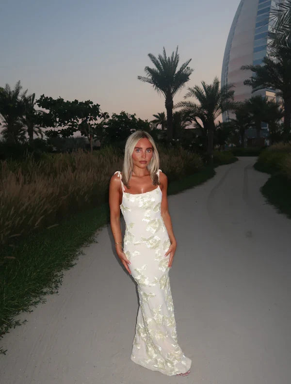 Feminine creme floral maxi dress with adjustable straps, an elegant choice for any special occasion.
