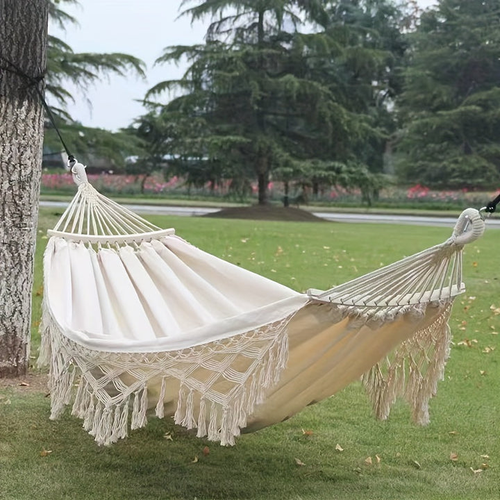 Striped bohemian hammock with decorative tassels, ultimate comfort for garden.