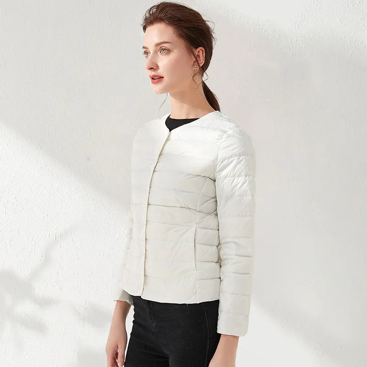 Layer-friendly women's lightweight puffer jacket. Collarless style offers a sleek, slimming silhouette.