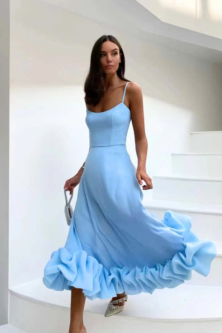 Bottom hem of women's graceful flowing midi dress, showcasing elegant movement; ideal for chic wedding guests.