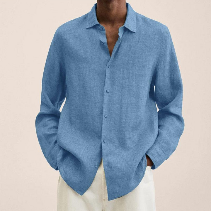 Detail shot of a high-quality men's long-sleeve button-up shirt fabric and classic buttons.