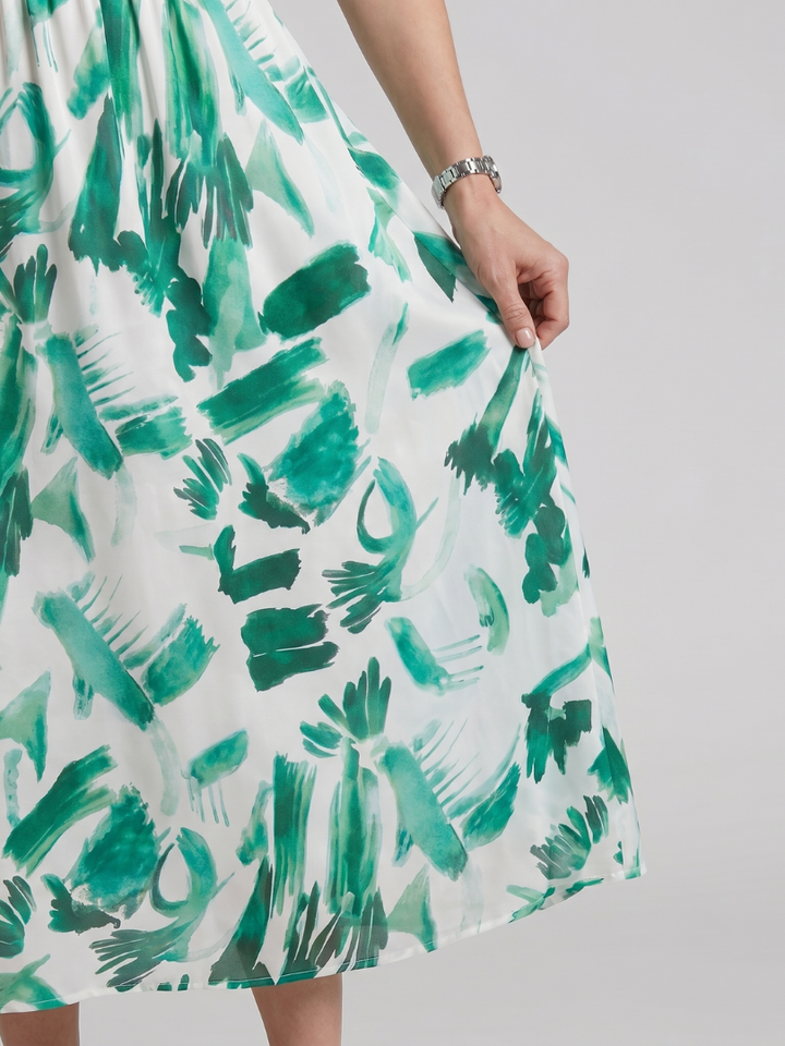 Woman smiling in abstract print midi dress, puff sleeves, V-neck. Perfect casual summer or spring vacation dress.