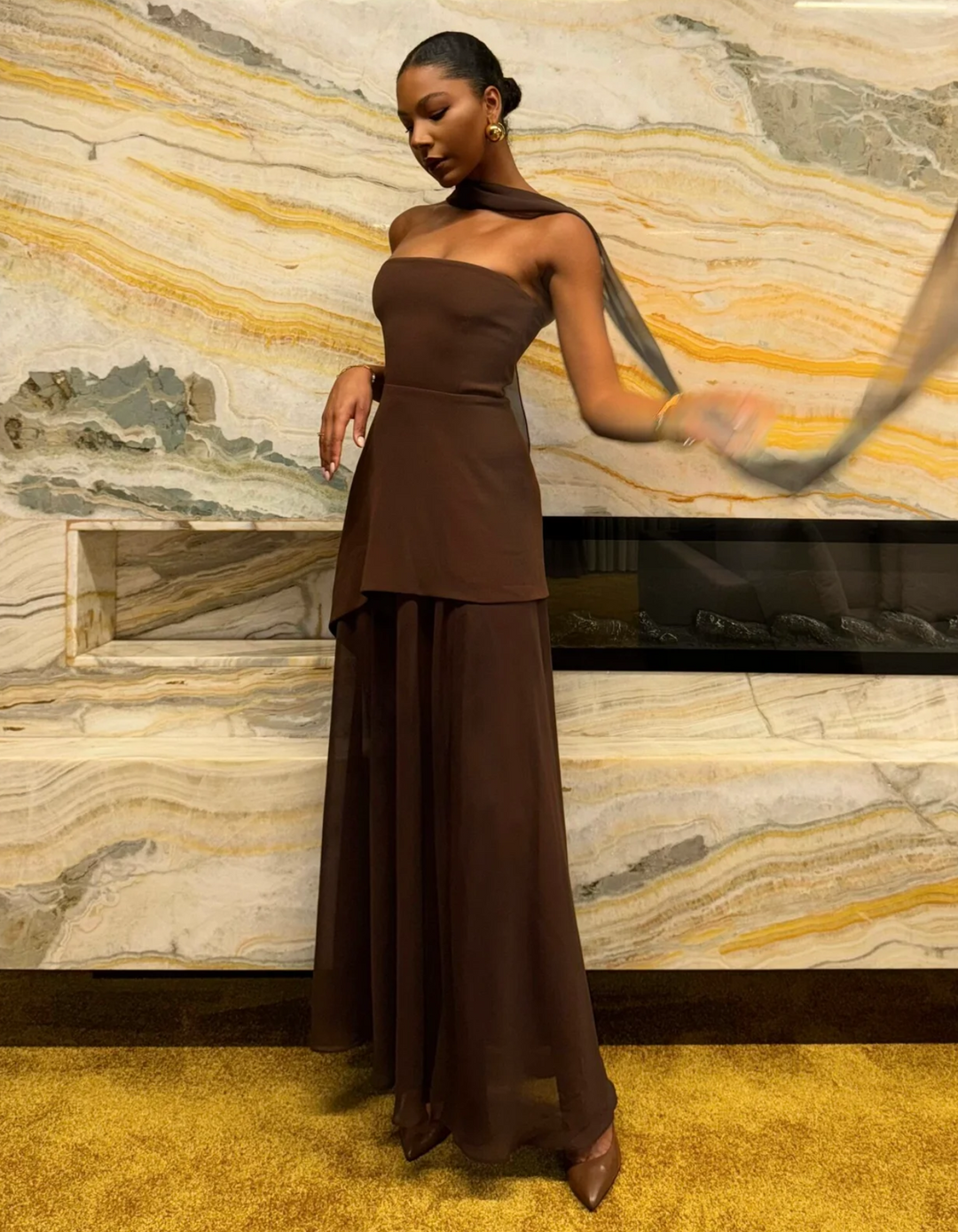 Styled women's strapless maxi dress with accessories, ready for a cocktail party or elegant evening event.