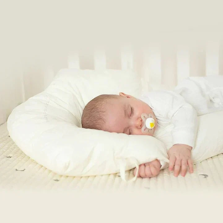Soft ergonomic baby cuddle cushion designed for infant sleep support, ensuring safe positioning and antibacterial comfort.