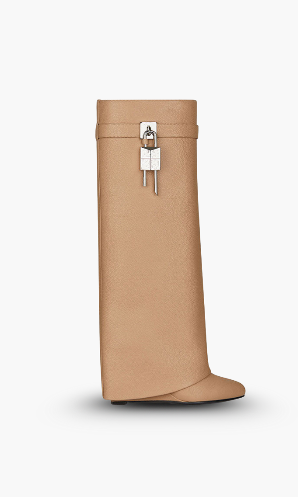 Women's sculptural knee-high boots, glossy finish and a distinct wedge heel for fashionistas.