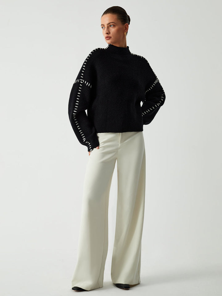 Comfortable women's oversized sweater showcasing its unique contrast stitch design and relaxed silhouette.