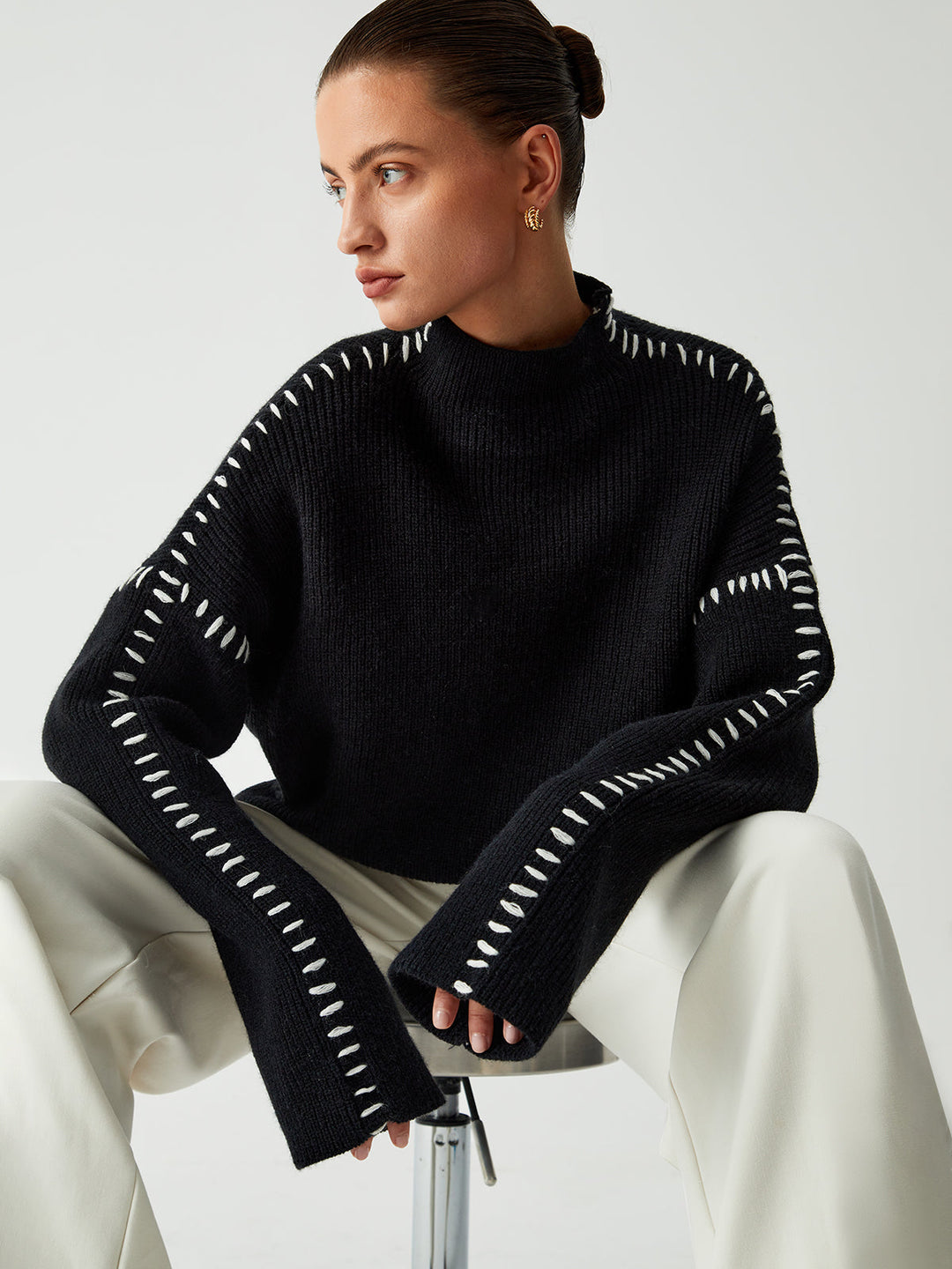 Fashionable women's oversized knitwear featuring prominent contrast stitching, perfect for stylish fall outfits.