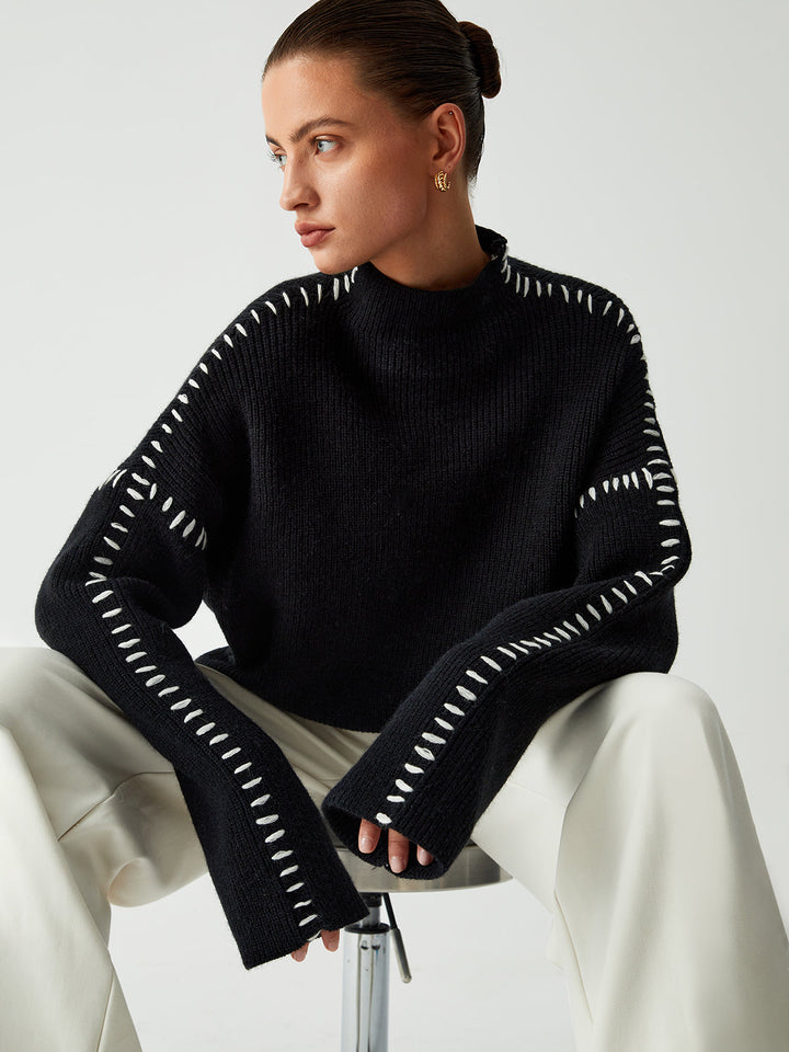 Fashionable women's oversized knitwear featuring prominent contrast stitching, perfect for stylish fall outfits.