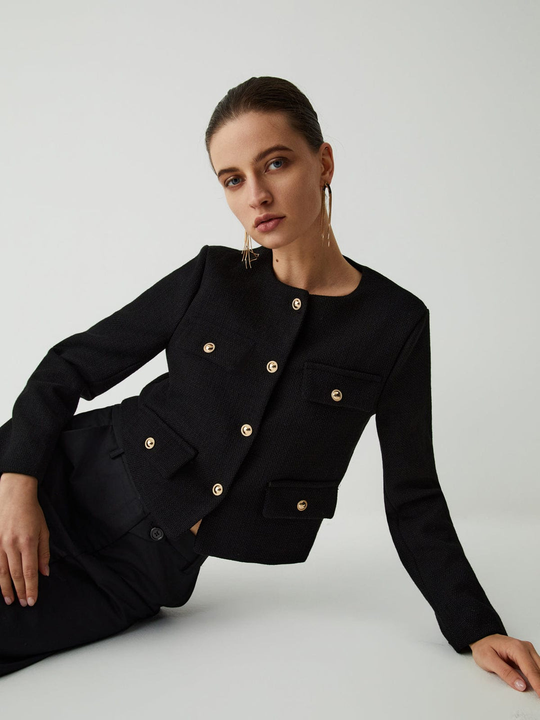 Chic women's cropped jacket with shining gold buttons, elegant for work or smart casual events.