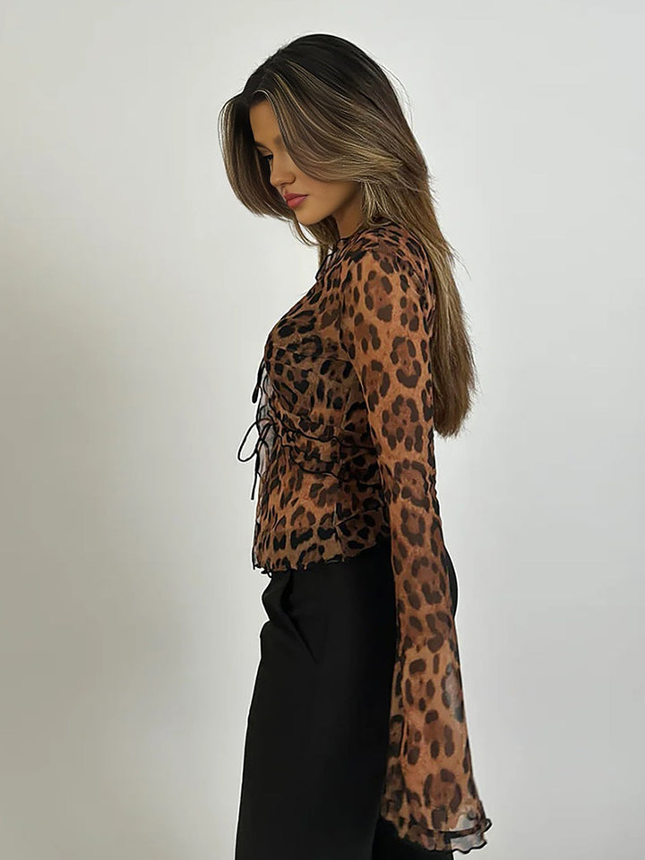 Fashionable women's sheer animal print top with flared long sleeves, tie front, and ruffle trim.