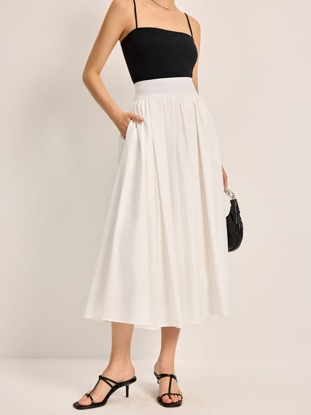 Elegant white A-line pleated women's skirt, perfect for versatile summer or spring occasions.