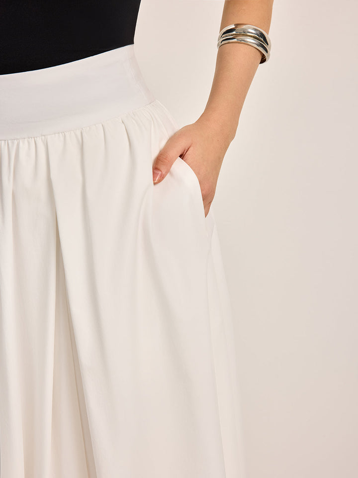 Elegant white A-line pleated skirt, a versatile women's fashion piece for spring and summer style.