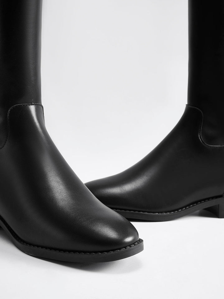 Women's sleek black knee-high riding boots, elegant & tall, a staple for classic fall & winter style.