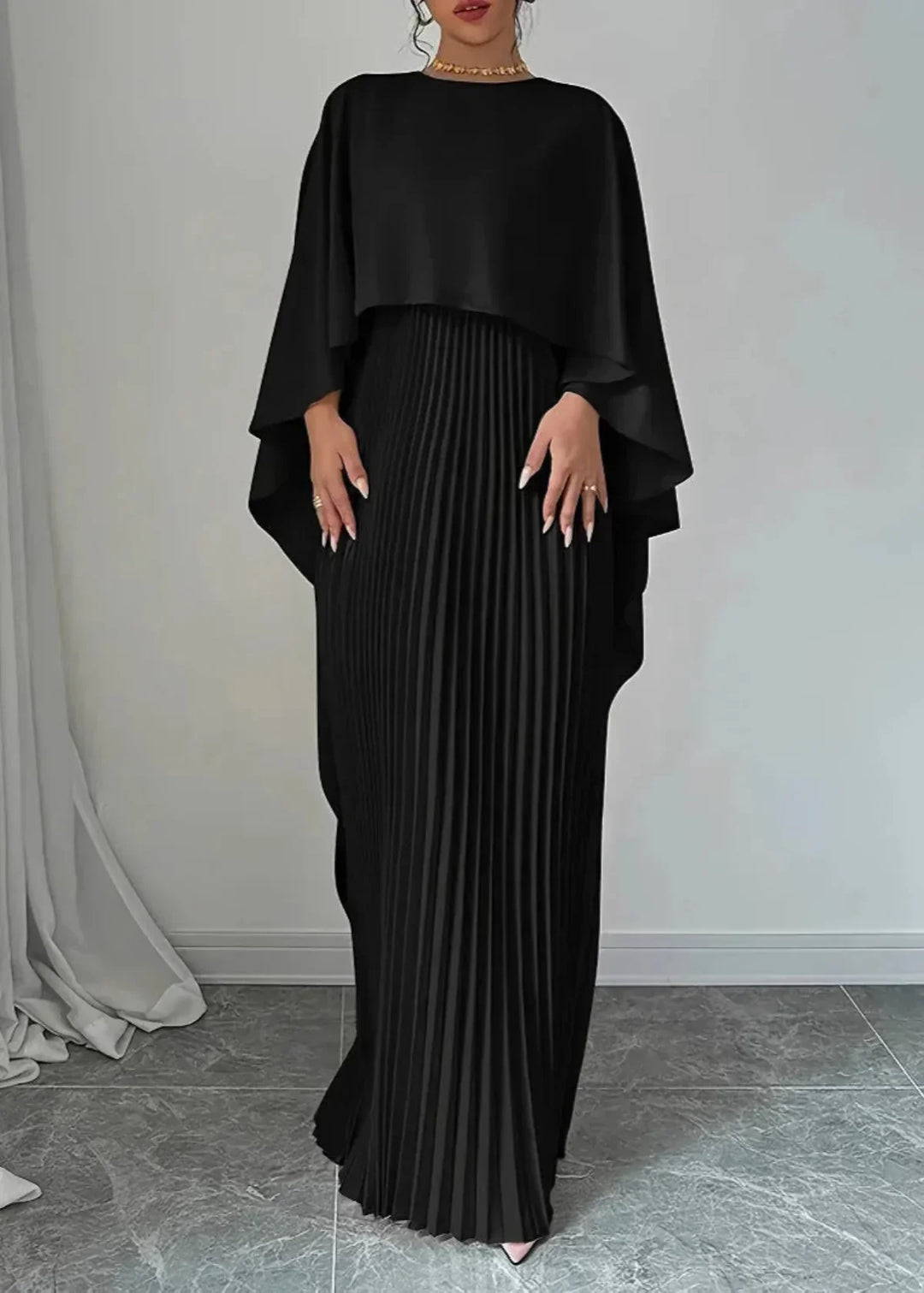 Sophisticated women's pleated maxi dress with a dramatic flowing cape, an elegant choice for evening events.