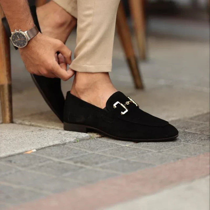 Detail shot: Men's sophisticated slip-on loafers, showcasing the elegant metal buckle and refined silhouette.