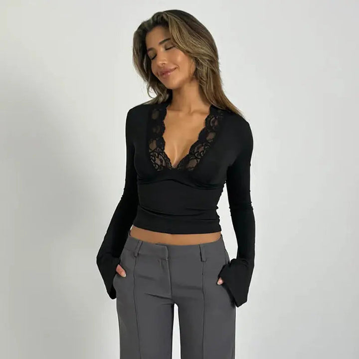 Fitted women's long-sleeve wrap top with ruched details, deep V-neck, and delicate lace trim.