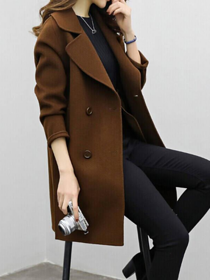 Stylish women's double-breasted longline coat with a flattering silhouette, essential fall/winter fashion.