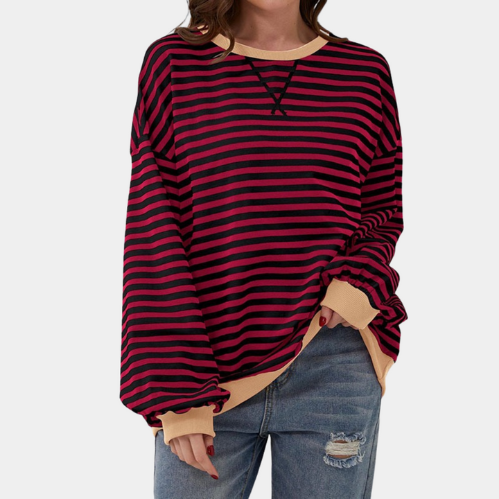 Woman wearing oversized striped long sleeve t-shirt, demonstrating its relaxed casual fit and everyday style.