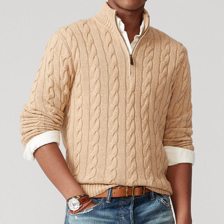 Close-up of a men's quarter-zip cable knit sweater, highlighting the intricate texture & mock neck.