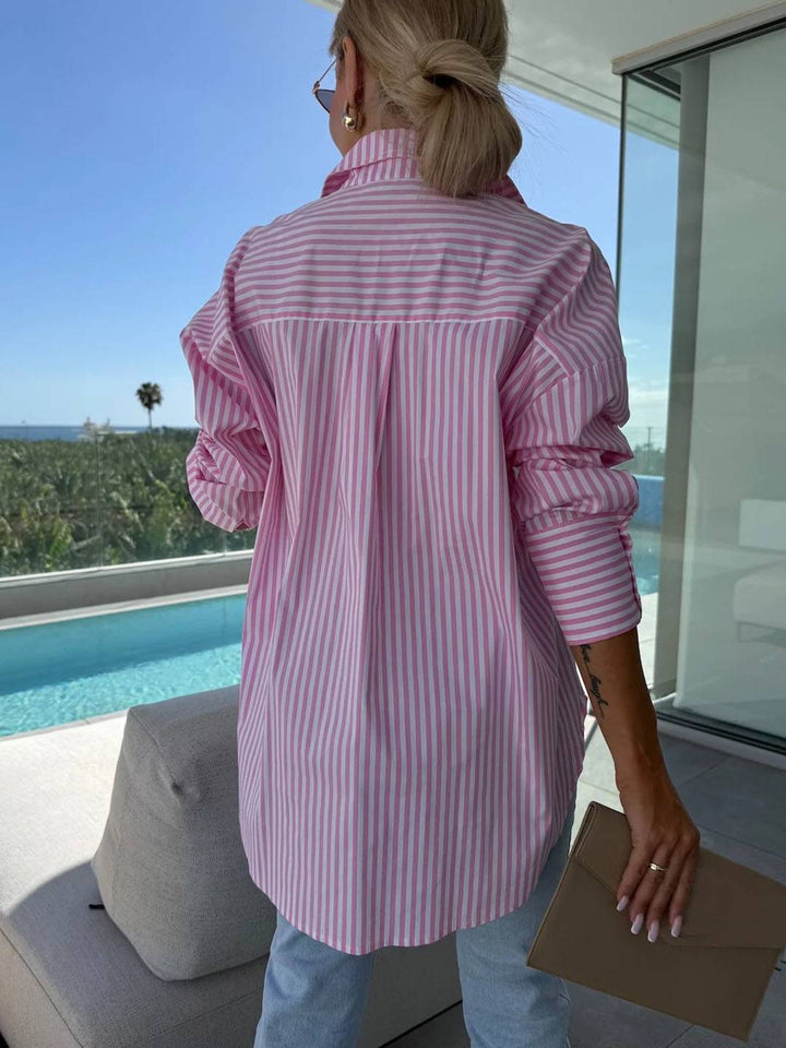 Close-up of the striped pattern & buttons on a women's stylish button-up blouse, long sleeve detail.