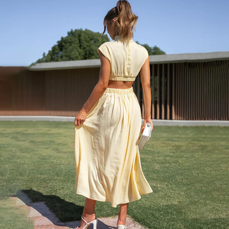 Woman wearing a stylish pleated cap sleeve midi dress. Elegant solid color, perfect for day or evening events.