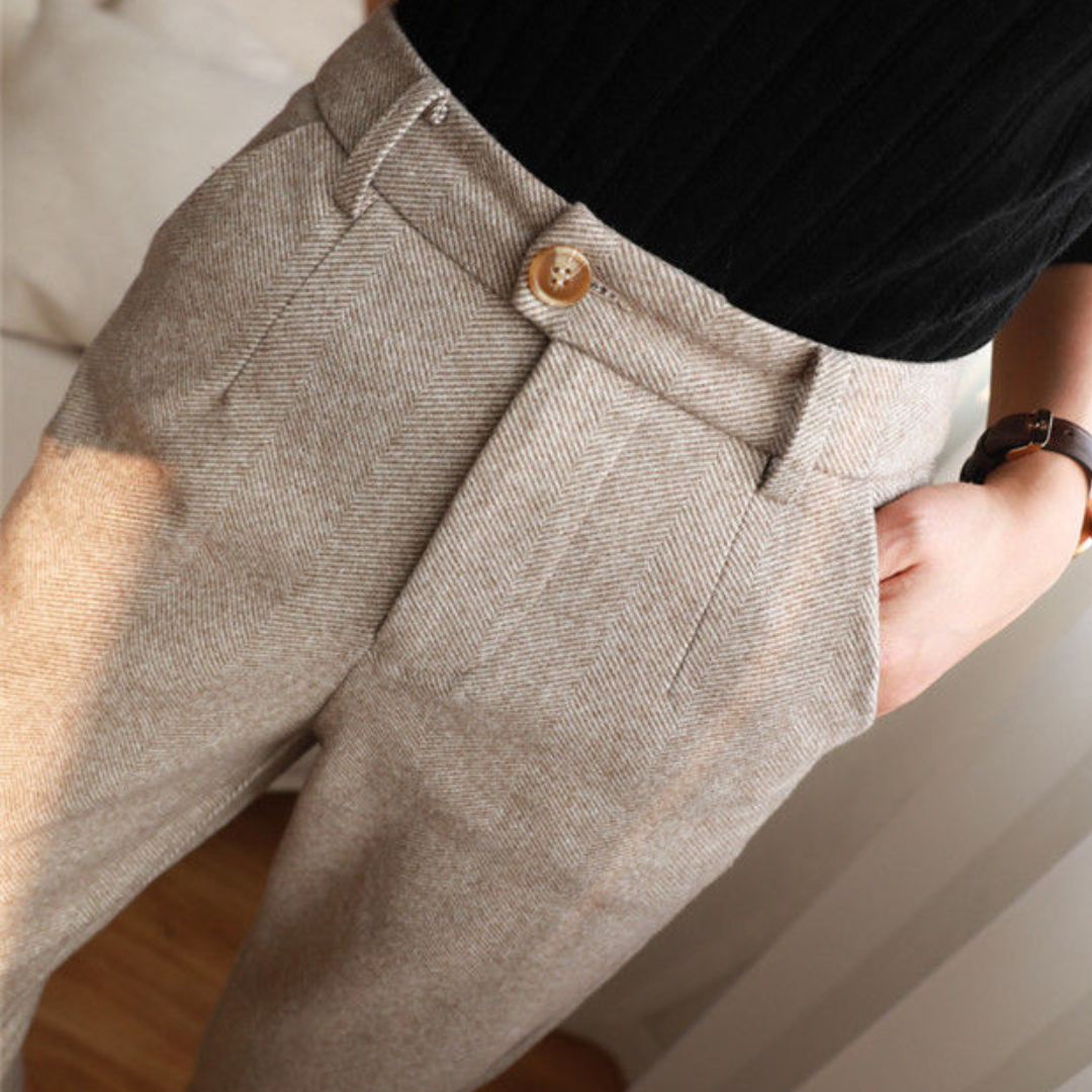 Woman walking in versatile herringbone all-season pants, showing comfortable movement. Elegant daily wear.