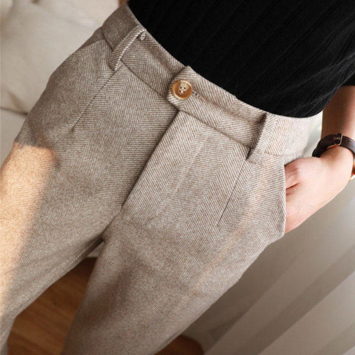 Woman walking in versatile herringbone all-season pants, showing comfortable movement. Elegant daily wear.