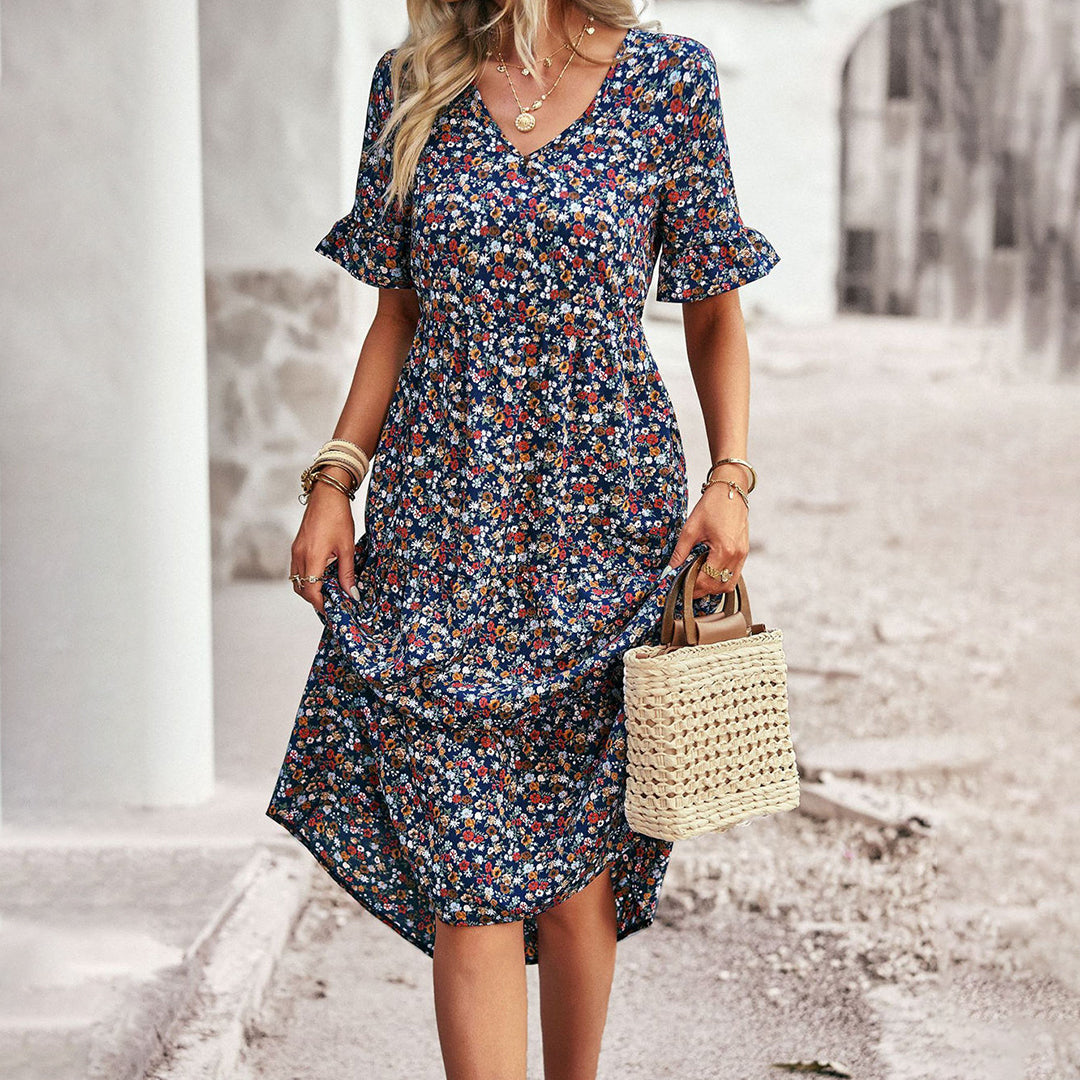 Stylish women's midi dress featuring a vibrant floral print and short sleeves, great for summer fashion.