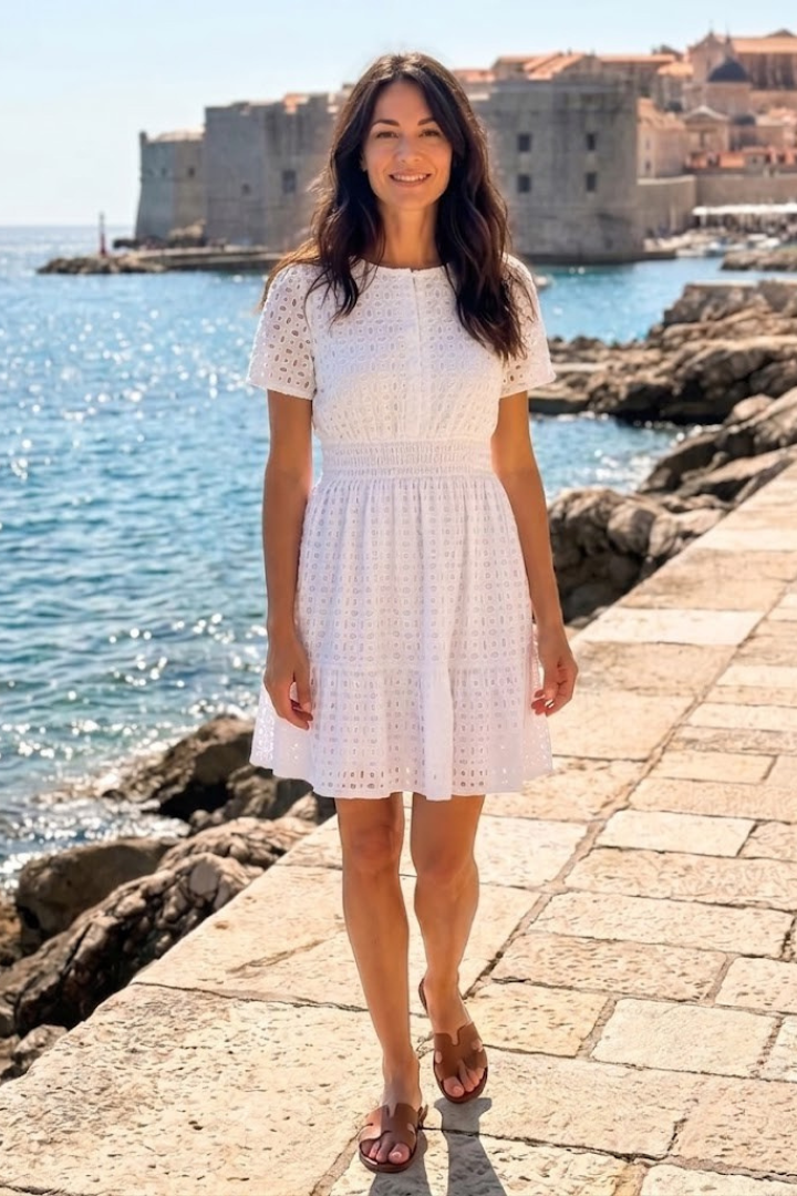 Casual women's day dress: short eyelet mini with airy flutter sleeves and a cute tiered hem, ideal for warm weather.