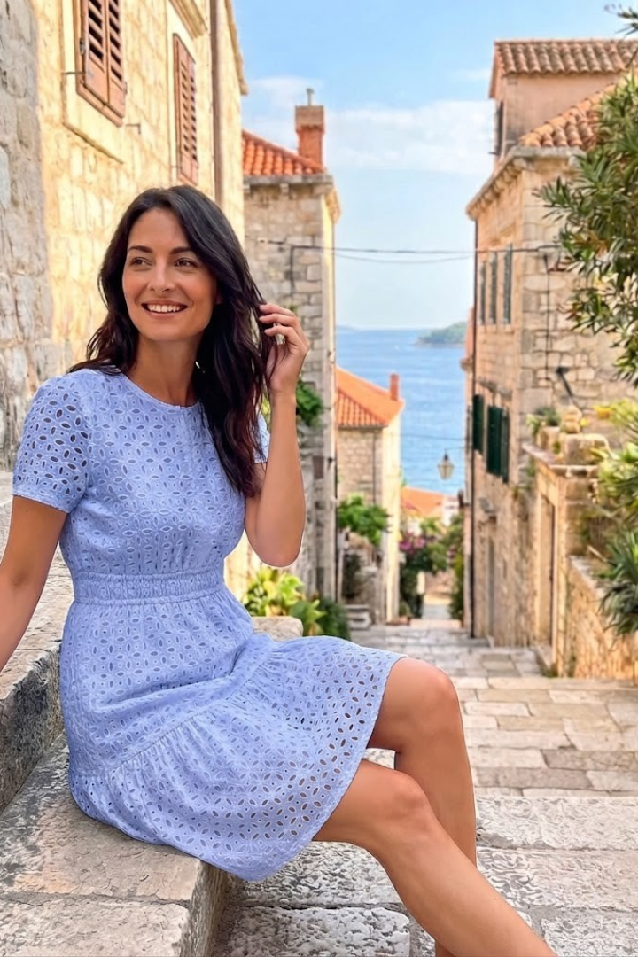 Lightweight women's casual mini dress, eyelet fabric, flutter sleeves, and a tiered hem, perfect for summer outings.