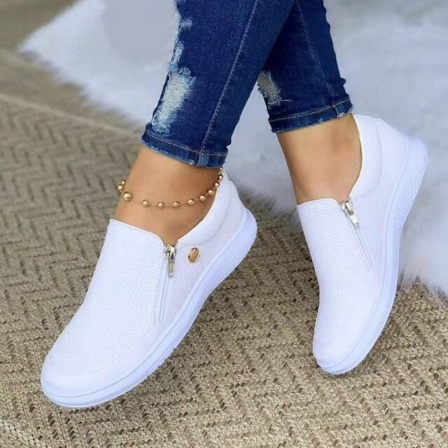 Comfortable women's platform slip-on sneakers featuring a convenient side zip, ideal casual footwear.