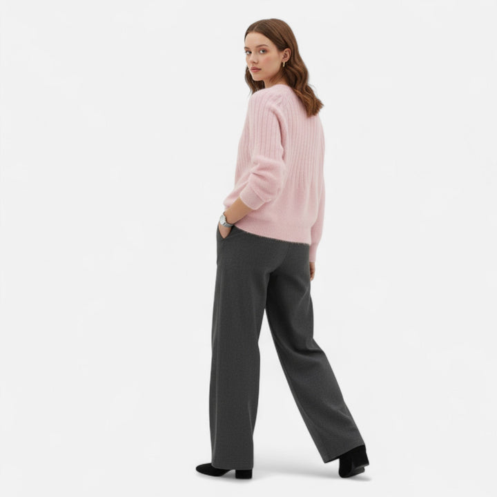 Woman wearing a versatile beige knit sweater, styled casually for everyday comfort and timeless fashion.