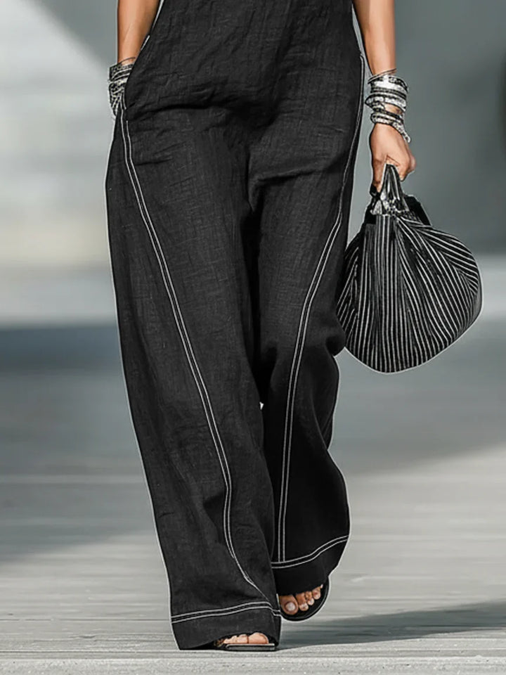 Stylish women's black sleeveless jumpsuit with crisp white trim, versatile for casual or elegant wear.