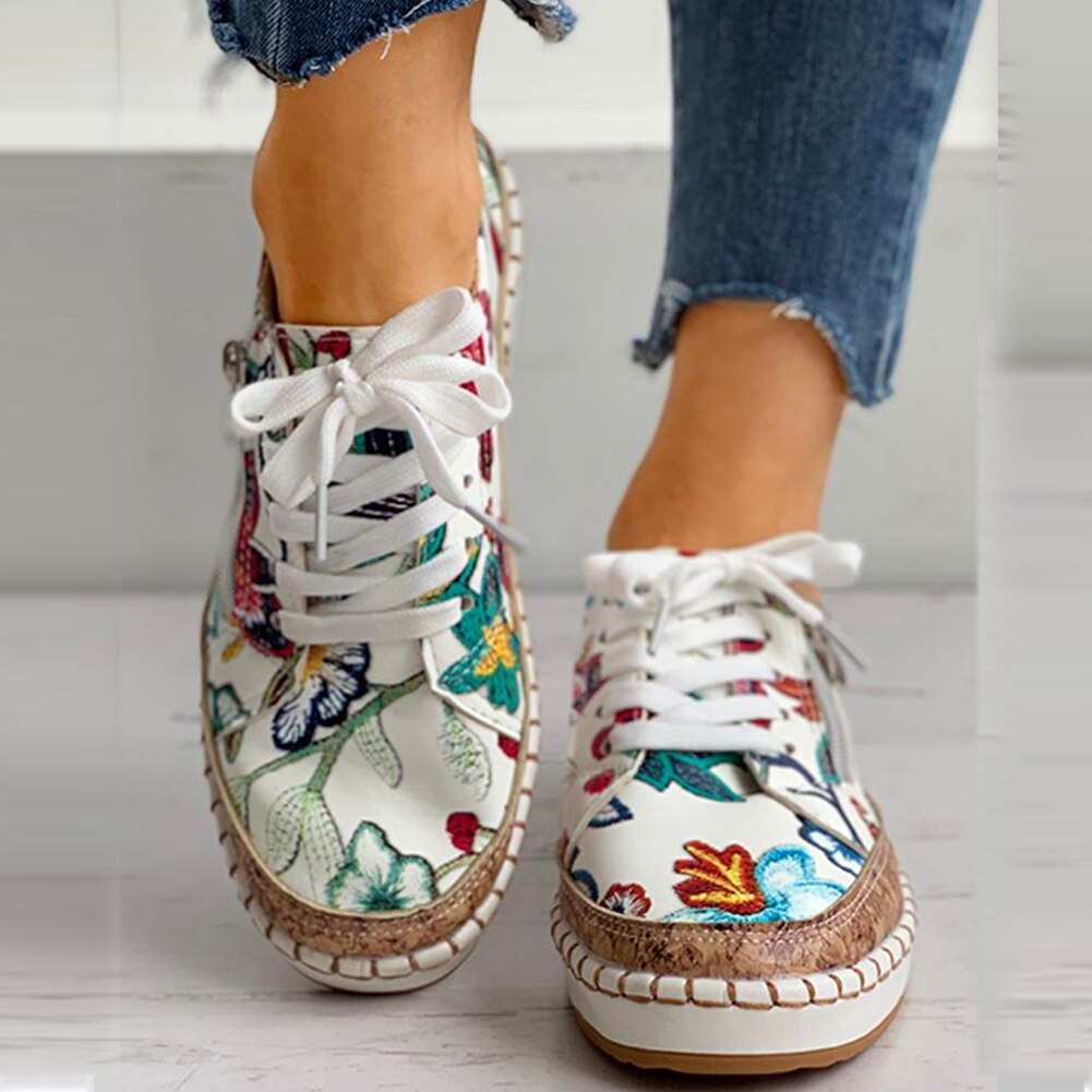 Front view: Women's orthopedic sports shoes in white with delicate floral accents, designed for ultimate comfort.