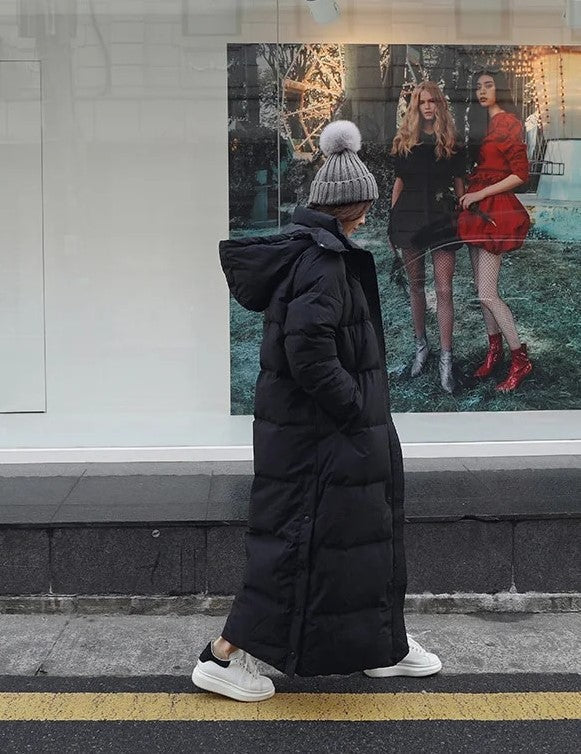 Women's long padded winter jacket with hood and zipper. Warm, water-repellent outerwear for cold weather.