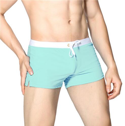 Man by the pool in modern quick-dry men's swim shorts with a comfort waistband.