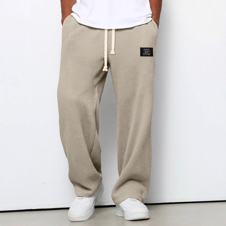 Detail of the comfortable waistband and practical pockets on men's relaxed everyday casual trousers.