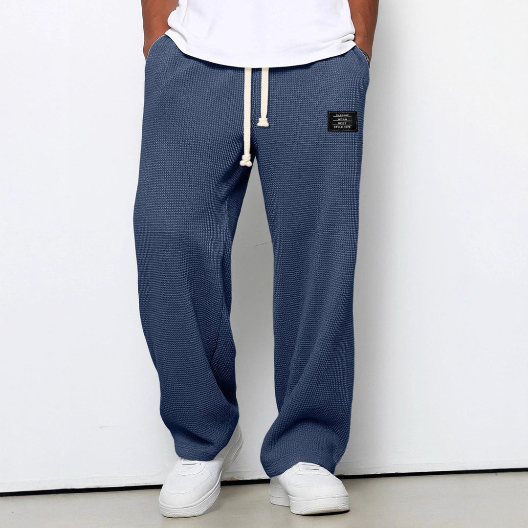Back view of men's relaxed everyday trousers on model, highlighting comfortable straight fit & casual style.