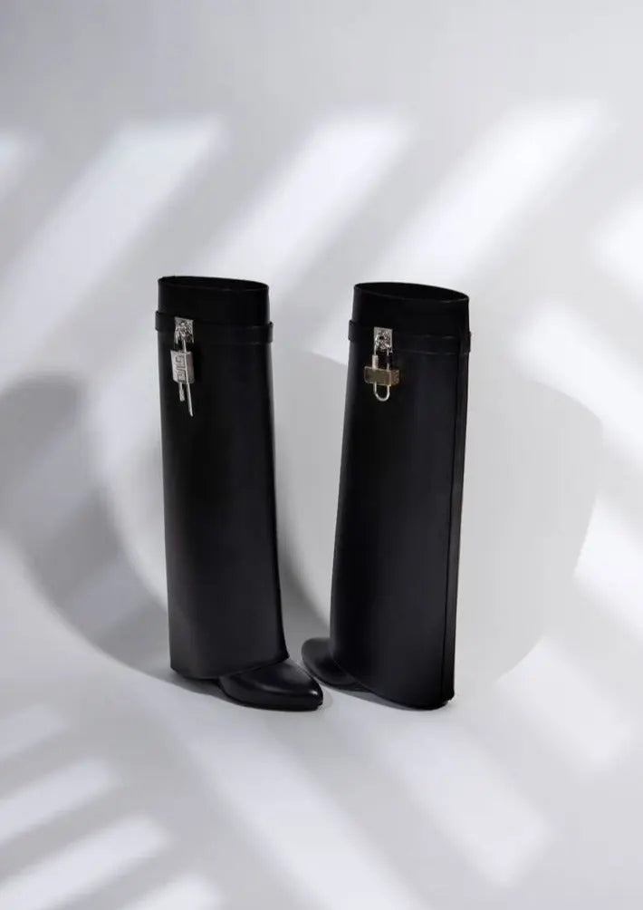 Sculptural wedge women's boots, knee-high and glossy, exuding modern elegant fashion.