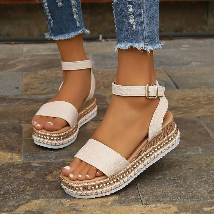 Black platform sandals for women with an ankle strap, offering versatile style and elevated comfort.