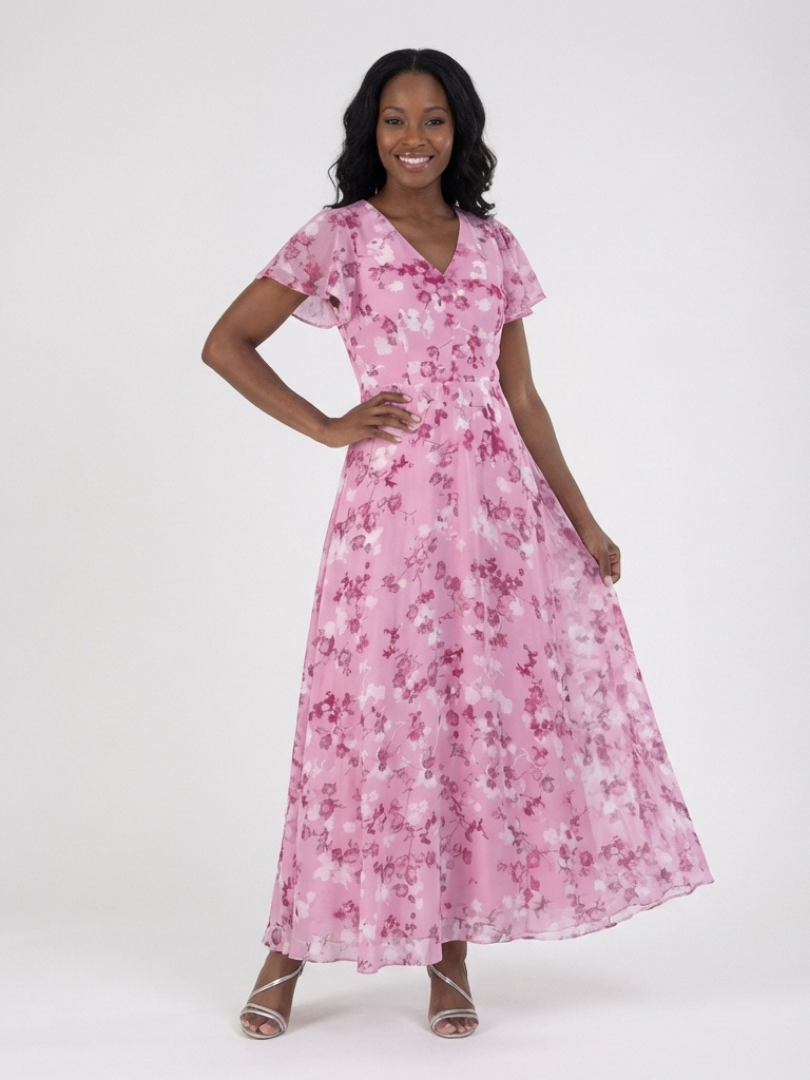 Woman wearing a flowing floral maxi dress with flutter sleeves, suitable for a summer outdoor party.