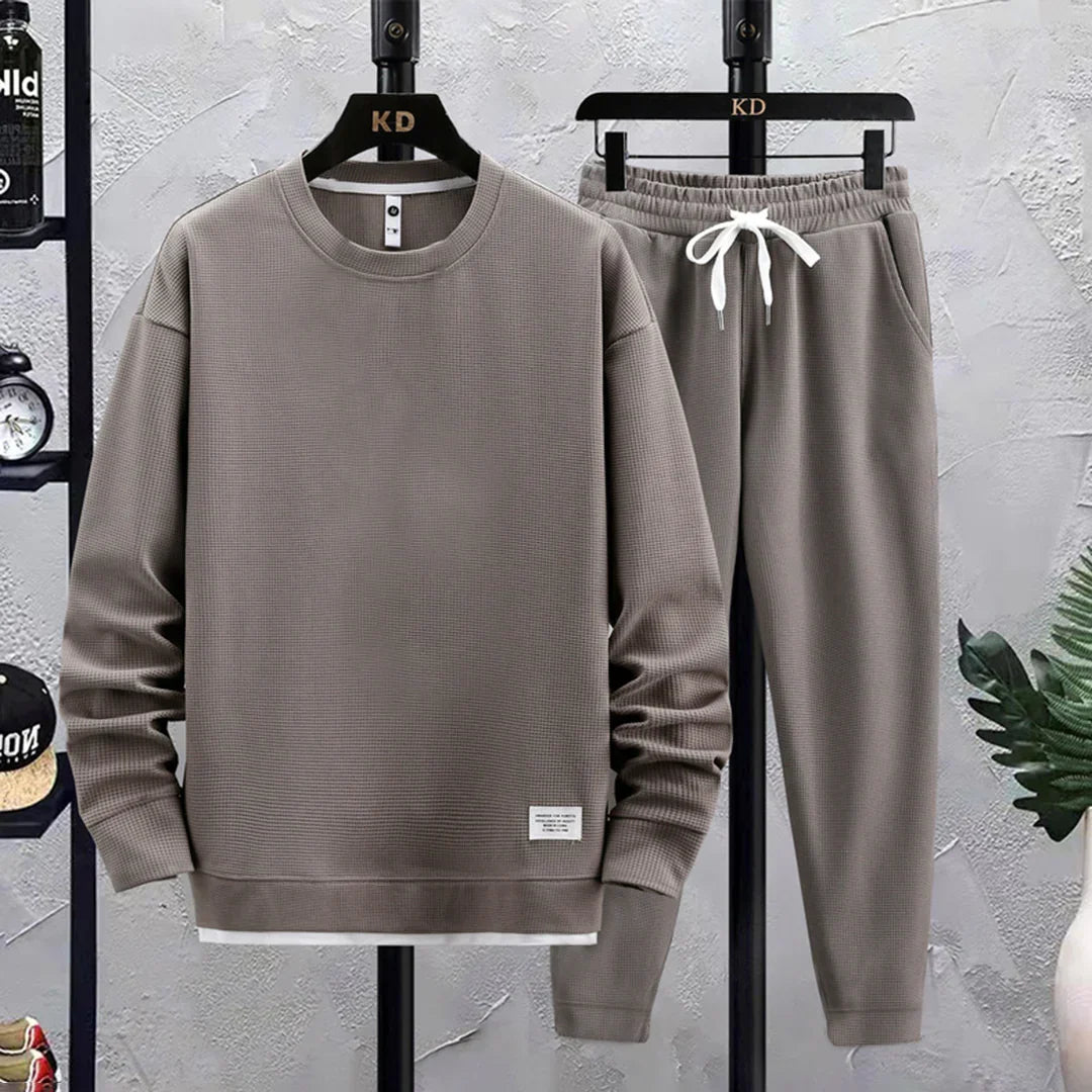 Men's athleisure tracksuit. Relaxed fit pullover & elastic waist pants for activewear or loungewear comfort.