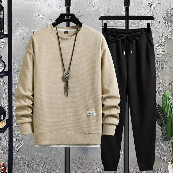 Sporty men's tracksuit featuring pullover top & elastic waist pants. A comfortable, relaxed fit athleisure set.