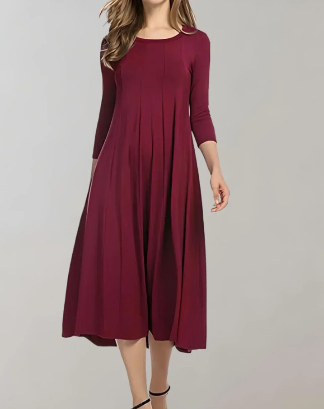 Stylish spring/summer women's midi dress with 3/4 sleeves, round neck, and elegant pleats.