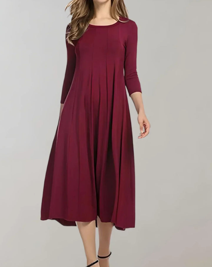 Stylish spring/summer women's midi dress with 3/4 sleeves, round neck, and elegant pleats.